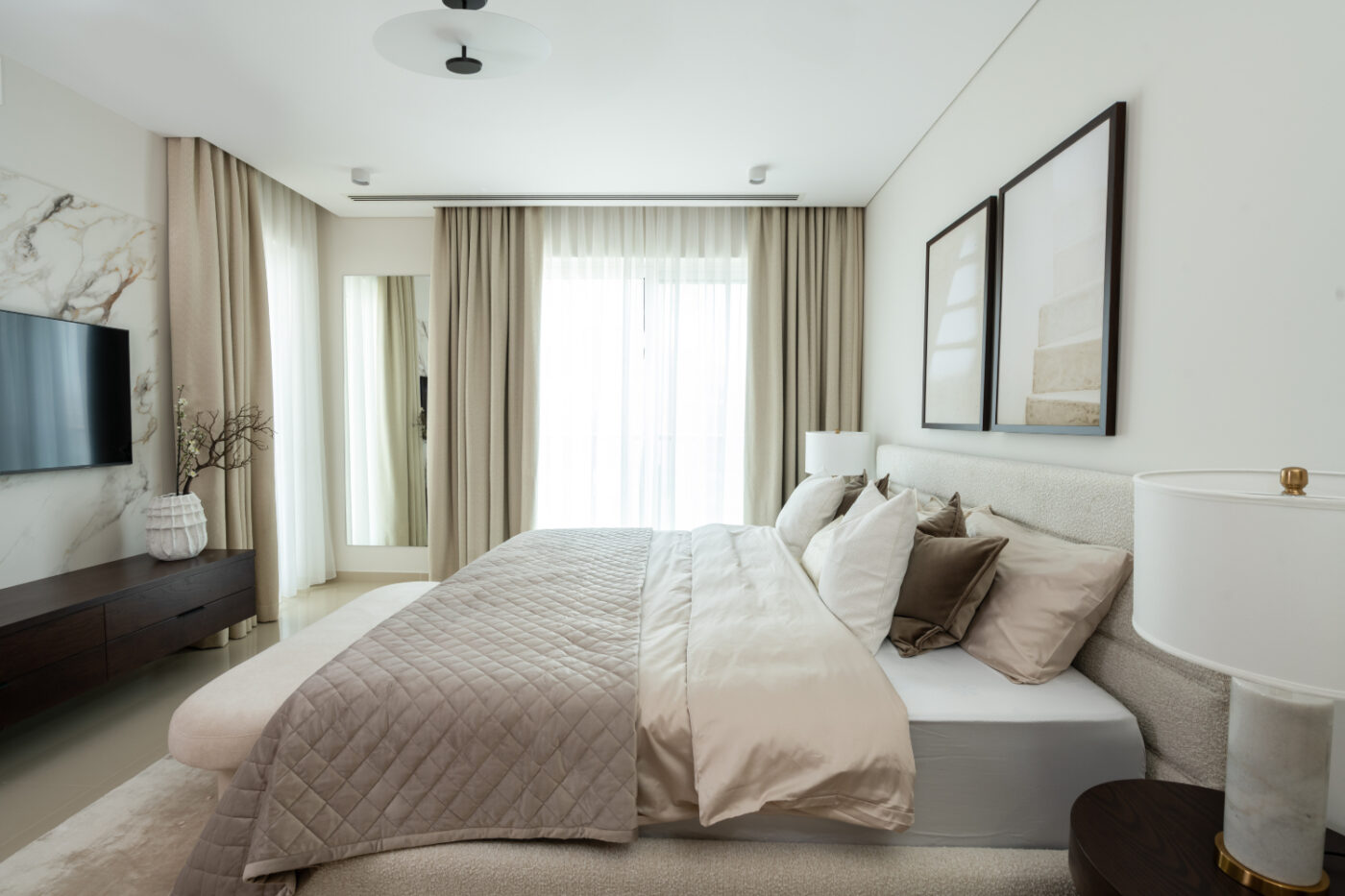 project by kate kerdi with yumi bed A modern feng shui bedroom showcasing a large bed and a wall-mounted television for entertainment.