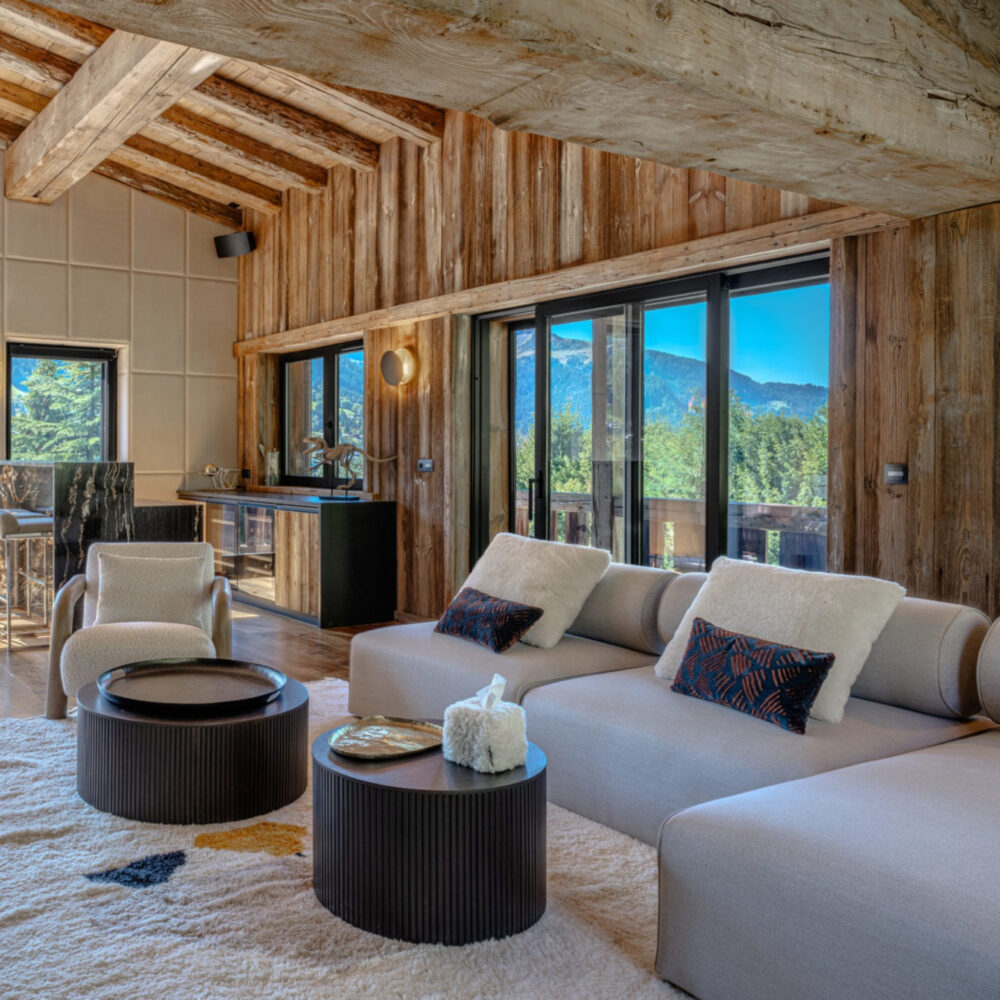 A charming living room adorned with wooden walls and a modular sofa, enhancing the room's warmth and character. By Aloona Design