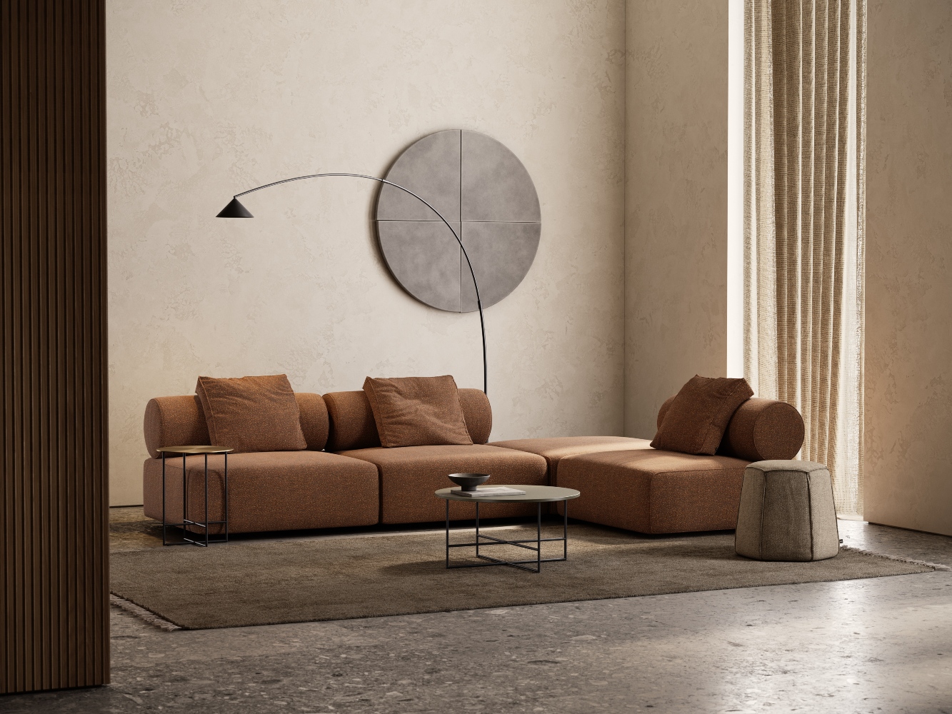 A modern living room with a brown sectional sofa, a round coffee table, and a tall arc floor lamp. A large circular wall art piece and a sculpted bust on a pedestal decorate the space. Natural light streams through a tall window.