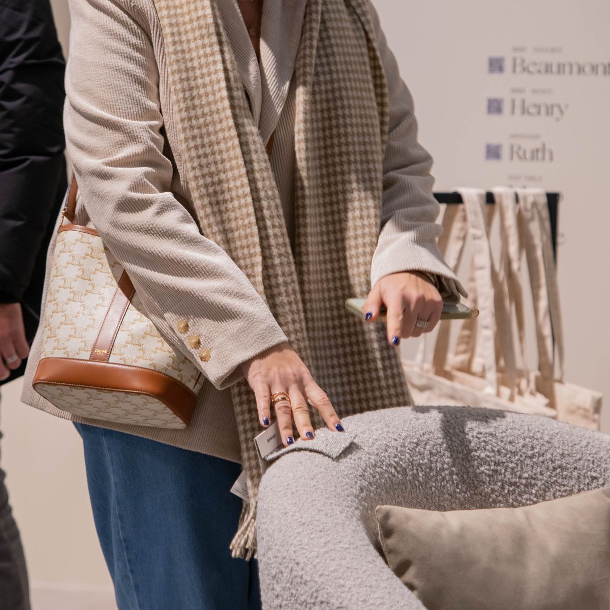 upholstery grades by domkapa A woman in a beige coat stands confidently, trying fabric swatches. Upholstery grades